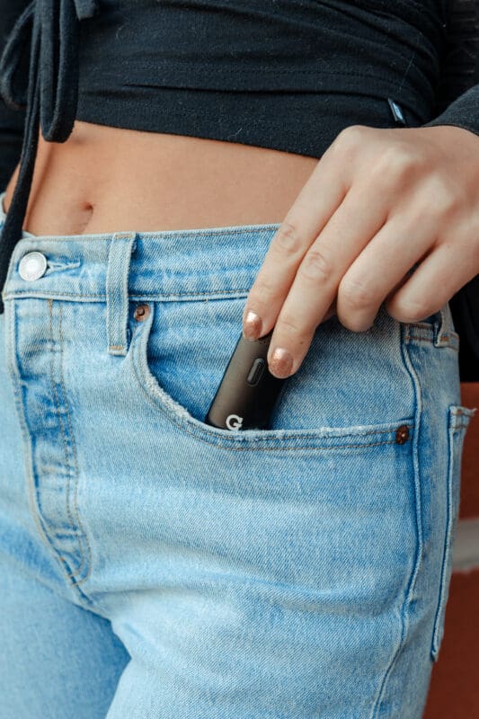 G Pen Dash in black being placed in lady's pocket.